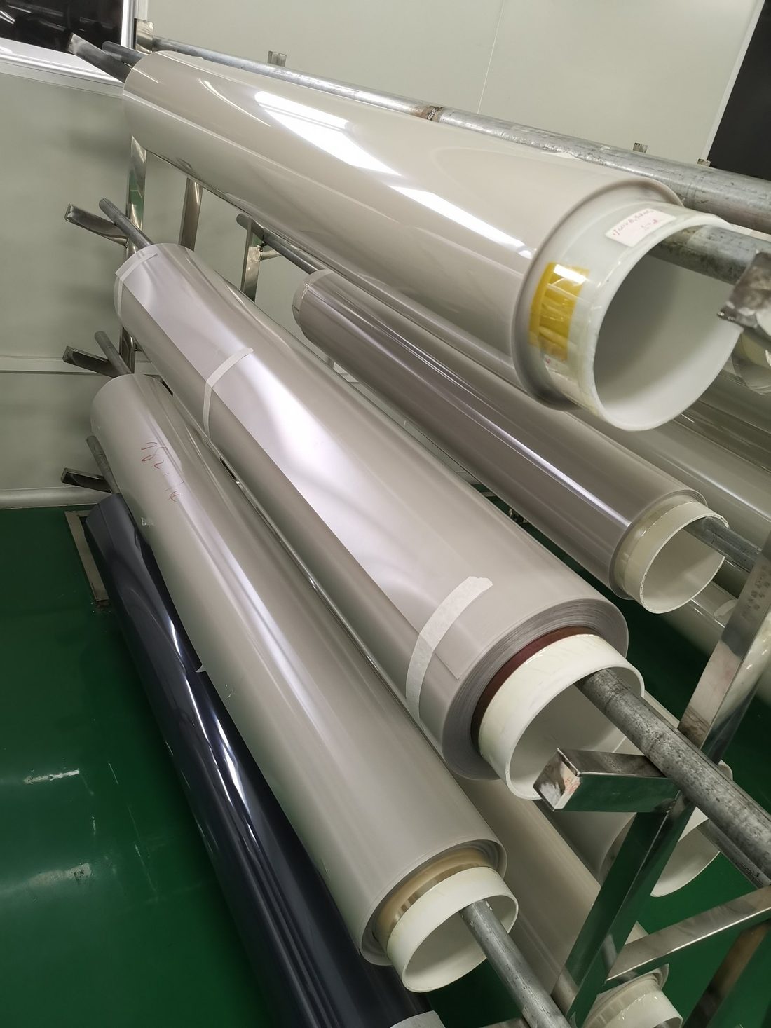 Rolls of finished PDLC smart film stored on racks