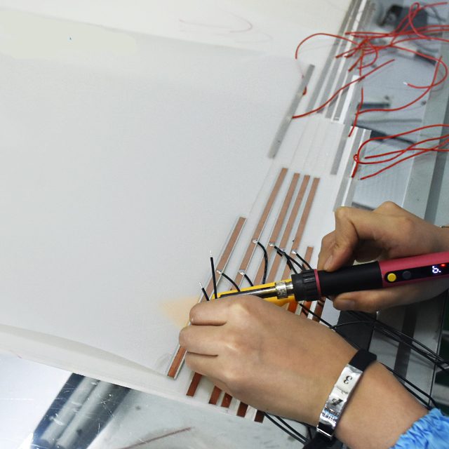 Soldering the electrode wire to the copper foil busbar of a smart film piece